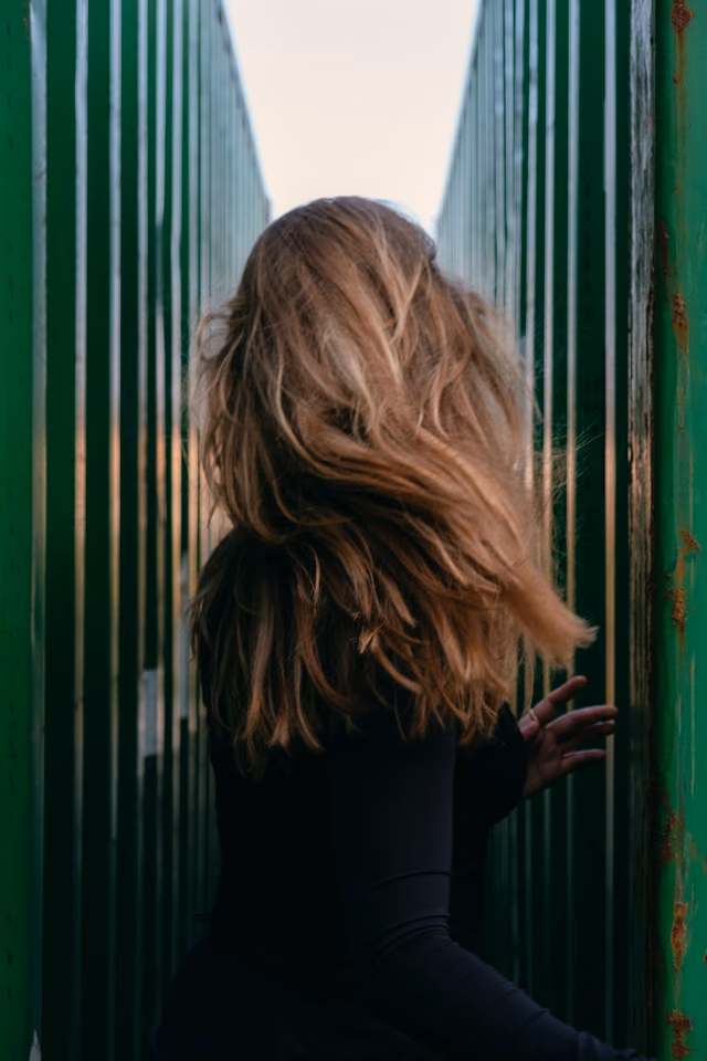 Long brunette waves with lighter ends, seen from behind
