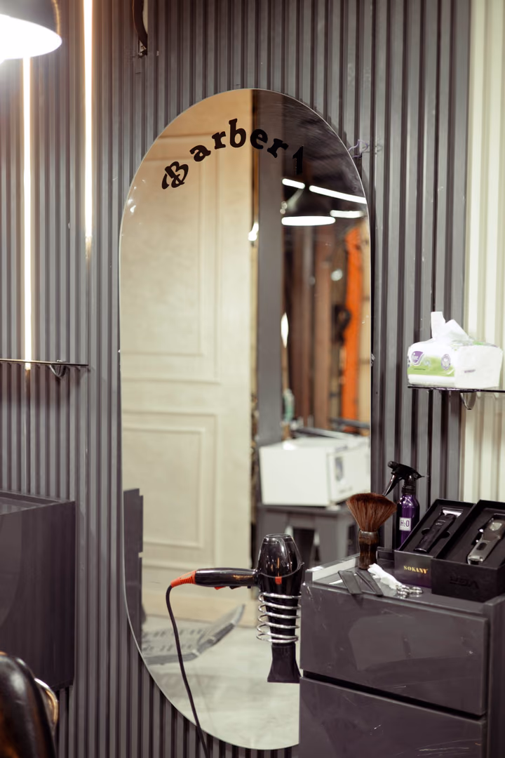A single styling station with a lit mirror in a quiet studio